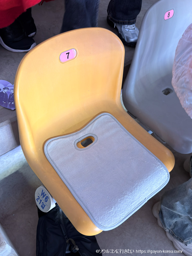 高陽スタジアムの冷たいベンチに3COINSで買ったチャイルドシート用防水パッドをセッティング